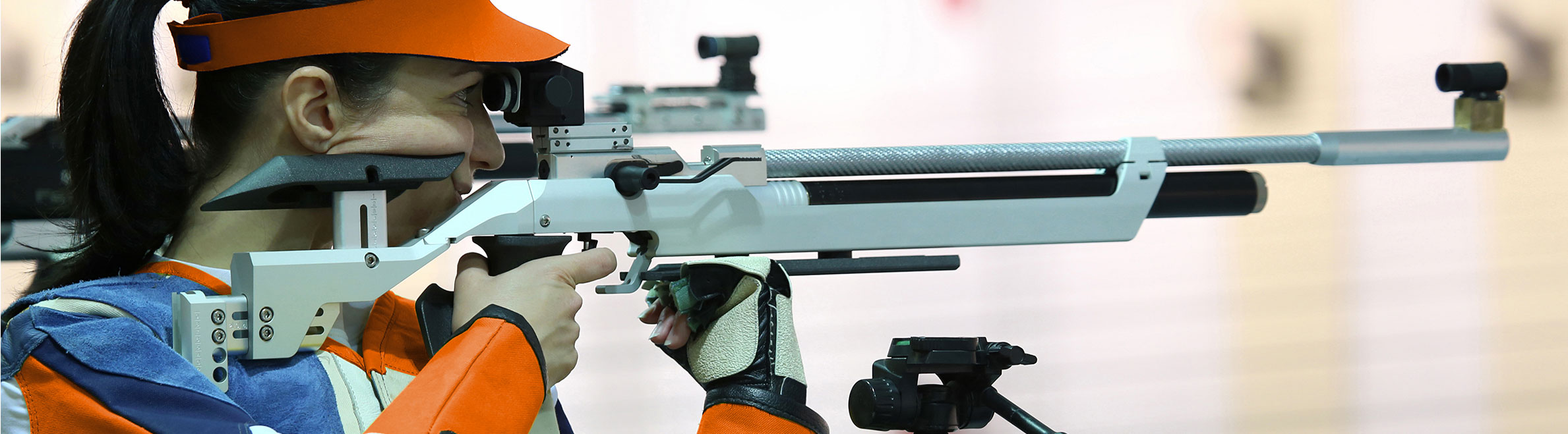 photo tireuse compétition carabine avec équipement en orange et bleu